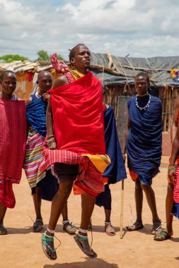 Kenya Afrika, 16 Ekim 2019. Afrika kabilesi Masai 'li erkekler geleneksel köylerinin arka planına karşı tam gelişim içinde.