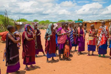 Kenya Afrika, 16 Ekim 2019. Afrika kabilesinden Maasai 'li kadınlar köy evlerinde kilden yapılmış ulusal elbiseler giyiyorlar.