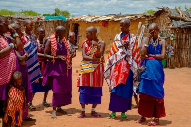 Kenya Afrika, 16 Ekim 2019. Afrika kabilesinden Maasai 'li kadınlar köy evlerinde kilden yapılmış ulusal elbiseler giyiyorlar.