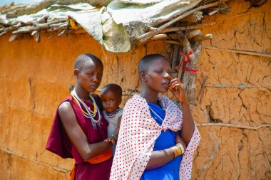 Kenya Afrika, 16 Ekim 2019. Afrika kabilesinden Maasai 'li kadınlar köydeki evlerinde kilden yapılmış ulusal elbiseler giyiyorlar.