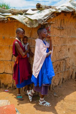 Kenya Afrika, 16 Ekim 2019. Afrika kabilesinden Maasai 'li kadınlar köydeki evlerinde kilden yapılmış ulusal elbiseler giyiyorlar.