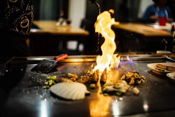 stock image Teppanyaki, Japanese Cooking teppan show at a traditional Japanese restaurant. hands of the cook. Japanese cook prepares meat, fish, rice, vegetables on the hot table