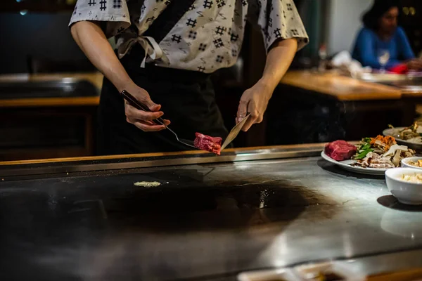 鉄板焼き 日本の伝統料理店での鉄板焼きショー 料理人の手だ 日本の料理人は熱いテーブルの上に肉 野菜を準備します — ストック写真
