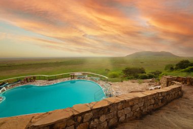 Mombasa, Kenya 15 Ekim 2019. Gün doğumunda safari otelinin yakınlarındaki Savannah 'da egzotik yüzme havuzu manzarası.