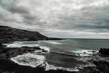 Fırtına sırasında mavi bir okyanusa düşen bir dalganın güzel hava manzarası. Seyahat manzarası konsepti
