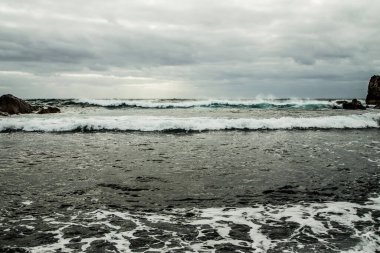 Fırtına sırasında mavi bir okyanusa düşen bir dalganın güzel hava manzarası. Seyahat manzarası konsepti