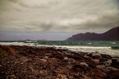 Fırtına sırasında mavi bir okyanusa düşen bir dalganın güzel hava manzarası. Seyahat manzarası konsepti