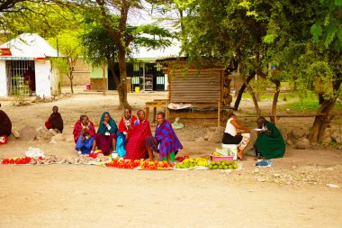 Arusha, Tanzanya, Afrika. 4 Şubat 2022 'de Afrika köyünde yaşam. Ulusal giysili Masailer sebze ve meyve satar. Afrika ve seyahat kavramı.
