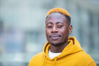 Akıllı telefonlu, sıradan sarı giyinmiş, duygusal, genç bir zenci. Mutlu yakışıklı Afro-Amerikan milenyum adamı iyi duyguları paylaşıyor, uzayı kopyalıyor. Kapat.