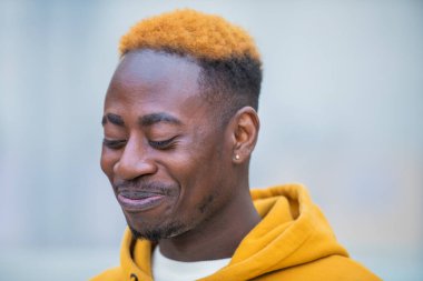 Akıllı telefonlu, sıradan sarı giyinmiş, duygusal, genç bir zenci. Mutlu yakışıklı Afro-Amerikan milenyum adamı iyi duyguları paylaşıyor, uzayı kopyalıyor. Kapat.