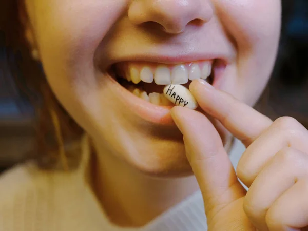 stock image oval white tablet with the inscription happy in the mouth of a teenager. Toxic depression anxiety drama and fear, antidepressant panic attack and psychology concept.