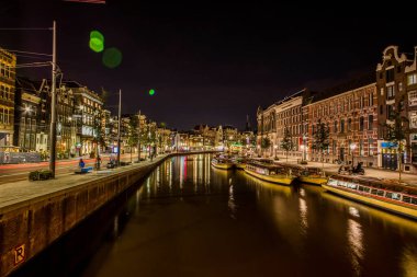 Amsterdam, Hollanda. 08 Eylül 2018. Modern Amsterdam şehir merkezi, kanallar ve köprüler. Büyük binalar ve küçük evler. Güzel turist rotası. akşam ışığı