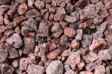 Süper Makro Himalaya Black Salt Kala Namak 'ı vurdu. Baharat ve vejetaryen konsepti. kahverengi pembe kristal arkaplan
