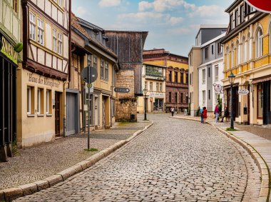 Quedlinburg, Saksonya-Anhalt, Almanya. 06 Temmuz 2021. Eski, eski, renkli evleri ve kaldırımları olan küçük bir kasaba. UNESCO Dünya Mirası Şehri. Avrupa seyahat kavramı