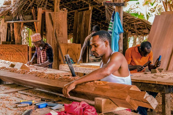 Stone Town, Zanzibar, Tanzanya. 27 Mart 2018. Afrika ahşap oymacılığı atölyesi. Muhteşem oyulmuş kapılar ve mobilyalar. Tanzanya 'da odun kesen zanaatkarlar
