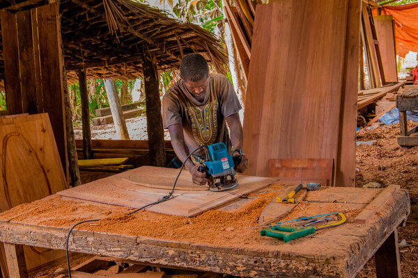 Stone Town, Zanzibar, Tanzania. 27 March 2018. Master woodcarver at work. Wood shavings, gouges and chisels on the workbench. Close up.