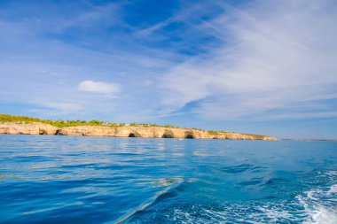 Garip şekiller kabartmalı kil taşlı kızıl uçurum Atlantik okyanus kıyıları güneş Portekiz Algarve ve su üzerinde kayık izleriyle aydınlanıyor..