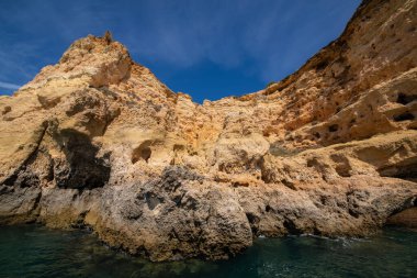 Kabartmalı kil taşlı kızıl uçurum Atlantik okyanus kıyısı. Güneş, Portekiz, Algarve seyahat konseptiyle aydınlanıyor.