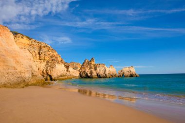 Garip şekiller kabartmalı kırmızı kayalık uçurum, Atlantik okyanus kıyısında güneş Portekiz Algarve 'i aydınlatıyor. Seyahat ve tatil konsepti