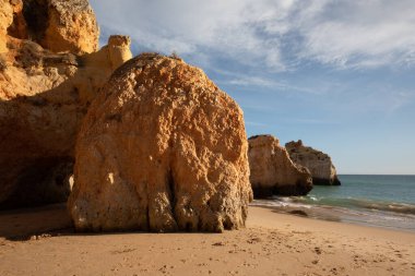 Garip şekiller kabartmalı kırmızı kayalık uçurum, Atlantik okyanus kıyısında güneş Portekiz Algarve 'i aydınlatıyor. Seyahat ve tatil konsepti