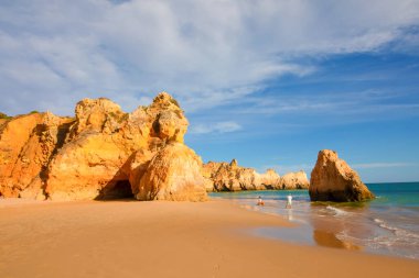 Garip şekiller kabartmalı kırmızı kayalık uçurum, Atlantik okyanus kıyısında güneş Portekiz Algarve 'i aydınlatıyor. Seyahat ve tatil konsepti