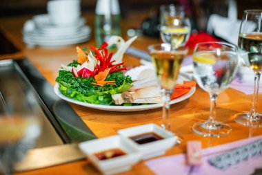 Japon Teppanyaki restoranını hazırlayan masa. Taze sebzeler ve bir bardak şarap.
