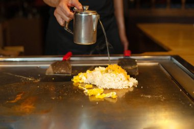 Şefin elleri teppanyaki yerine spatula ile. Sebze pişirmek et ve deniz ürünleri sıcak hibachi ızgara masasında. Geleneksel Japon mutfağı. Teppan gösterisi