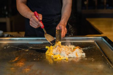 Şefin elleri teppanyaki yerine spatula ile. Sebze pişirmek et ve deniz ürünleri sıcak hibachi ızgara masasında. Geleneksel Japon mutfağı. Teppan gösterisi