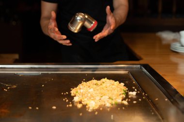 Şefin elleri teppanyaki yerine spatula ile. Sebze pişirmek et ve deniz ürünleri sıcak hibachi ızgara masasında. Geleneksel Japon mutfağı. Teppan gösterisi