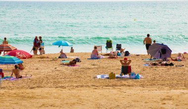 Portimao, Portiman, Algarve, Portekiz. 27.09.2020. Sıcak güneşli bir günde Portekiz 'de halk plajı. Okyanus kıyısında bir sürü insan var. Avrupa seyahati ve tatil konsepti