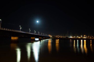 Portimao, Portiman, Algarve, Portekiz. Portimamamamao şehrine bakan Arade nehri üzerindeki Portimaobristeki Portimaobridges 'de 27.09.2020 Portekiz metal kemeri. Gece vakti Ponte Velha eski köprüsü