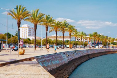 Portimao, Portiman, Algarve, Portekiz. Portimao 'daki 27.09.2020 nehir ve okyanus seti palmiye ağaçları ve banklarla dolu geniş bir gezinti alanı. Avrupa ve okyanus yolculuğu kavramı