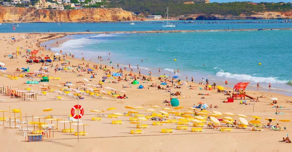 Portimao, Portiman, Algarve, Portekiz. 27.09.2020. Sıcak güneşli bir günde Portekiz 'de halk plajı. Okyanus kıyısında bir sürü insan var. Avrupa seyahati ve tatil konsepti