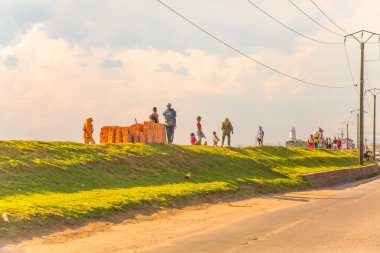 Antananarivo, Talatamaty, Madagaskar. 25 Ekim 2023 Antananarivo Caddesi. Madagaskar 'ın başkenti ve en büyük şehri. İnsanlar toprak seti boyunca arka planda mavi gökyüzüne karşı yürür.