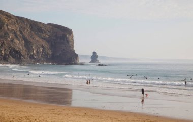Atlantik kıyısında güzel bir körfez aynalı ıslak plaj ve etrafındaki dağlarla. Sörf ve rahatlama. Spor ve seyahat konsepti. Deniz manzarası arka planı. Portekiz, Arrifana