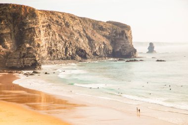 Atlantik kıyısında güzel bir körfez aynalı ıslak plaj ve etrafındaki dağlarla. Sörf ve rahatlama. Spor ve seyahat konsepti. Deniz manzarası arka planı. Portekiz, Arrifana