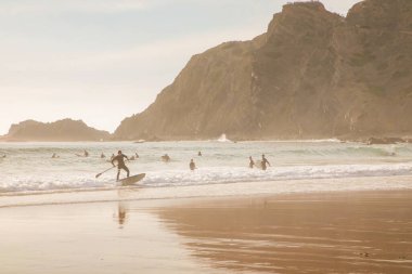 Atlantik kıyısında güzel bir körfez aynalı ıslak plaj ve etrafındaki dağlarla. Sörf ve rahatlama. Spor ve seyahat konsepti. Deniz manzarası arka planı. Portekiz, Arrifana