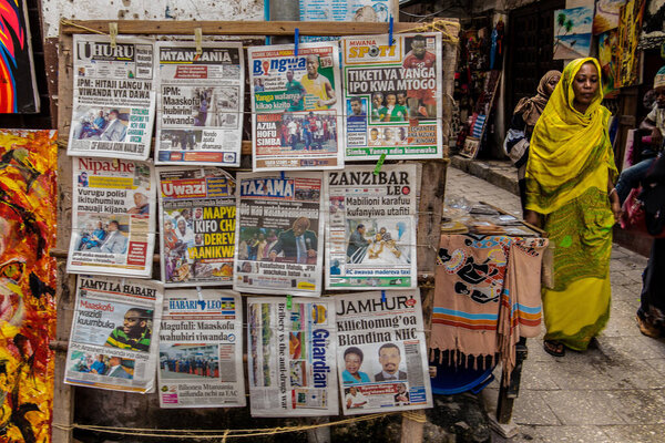 Занзибар, Танзания, Африка. 26 марта 2018.Stone Town capital of Zanzibar. узкие улочки, старые дома, люди, идущие по дороге, рынку, газете
