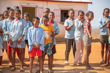 Miandrivazo, Madagaskar 20 Ekim 2023. Küçük bir bölge okulundaki birkaç köyden gelen mutlu okul çocukları bir katlı köy okulunun önünde duruyorlar..