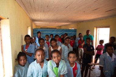 Miandrivazo, Madagaskar 20 Ekim 2023. Sınıfta mutlu okul çocukları var. Okul çocukları gülümser ve öğretmene bakar. Sınıfta bir sürü çocuk var. Çoğu çocuk yalın ayaktır.