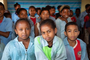 Miandrivazo, Madagaskar 20 Ekim 2023. Sınıfta mutlu okul çocukları var. Okul çocukları gülümser ve öğretmene bakar. Sınıfta bir sürü çocuk var. Çoğu çocuk yalın ayaktır.