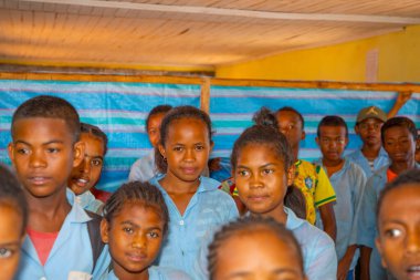 Miandrivazo, Madagaskar 20 Ekim 2023. Sınıfta mutlu okul çocukları var. Okul çocukları gülümser ve öğretmene bakar. Sınıfta bir sürü çocuk var.