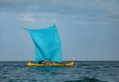 Morondava, Madagaskar. 18 Ekim 2023. Madagaskar Malagasy balıkçısı ev yapımı ahşap pirogue teknesiyle ev yapımı basit yelkenli altında balık yakalıyor. Okyanus manzarası