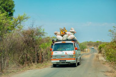 Antsirabe, Madagaskar 19 Ekim 2023. Morondava 'dan Antsirabe' ye giden yol Madagaskar 'ın merkezindeki köyden geçiyor. Geleneksel Madagaskar kargo taksi minibüsü bir şeyler ve ürünlerle dolu.