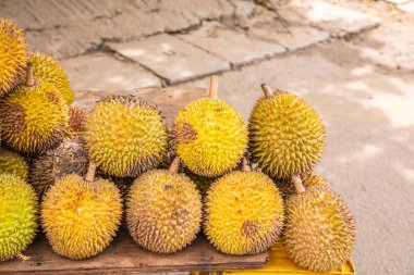 Olgun sarı durian meyveleri ahşap tezgahın üzerinde katlanmış satılıktır. Sri Lanka 'nın geleneksel meyveleri