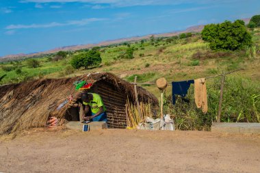 Antsirabe, Madagaskar 19 Ekim 2023. Morondava 'dan Antsirabe' ye giden yol Madagaskar 'ın ortasındaki boş otlaklar ve köyden geçiyor. Yolun kenarındaki küçük sazdan evler