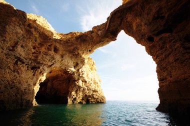 Portekiz 'in Algarve kıyısındaki okyanusta gün batımında şaşırtıcı derecede güzel kayalar. Altın güneş ışınları. Lagos Porugal