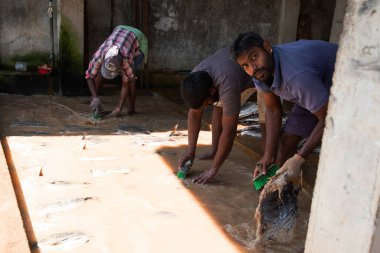 Negombo, Sri Lanka. 09 Şubat 2023 'te Sri Lanka' da küçük bir balık fabrikasında çalışan işçiler ayaklarıyla çamurlu ve kirli suda fileto balığı yıkarlar..