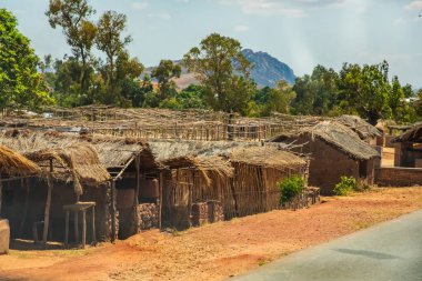 Antsirabe bölgesi, Madagaskar. 20 Ekim 2023. Madagaskar yolları. Antsirabe yolu. Küçük köyler, yol boyunca kil ve dallardan yapılmış geleneksel Malagasy evleri, çiftlik hayvanları, günlük yaşam Malagasy..