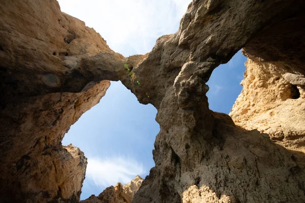 Portekiz 'in Algarve kıyısındaki okyanusta gün batımında şaşırtıcı derecede güzel kayalar. Altın güneş ışınları. Lagos Porugal